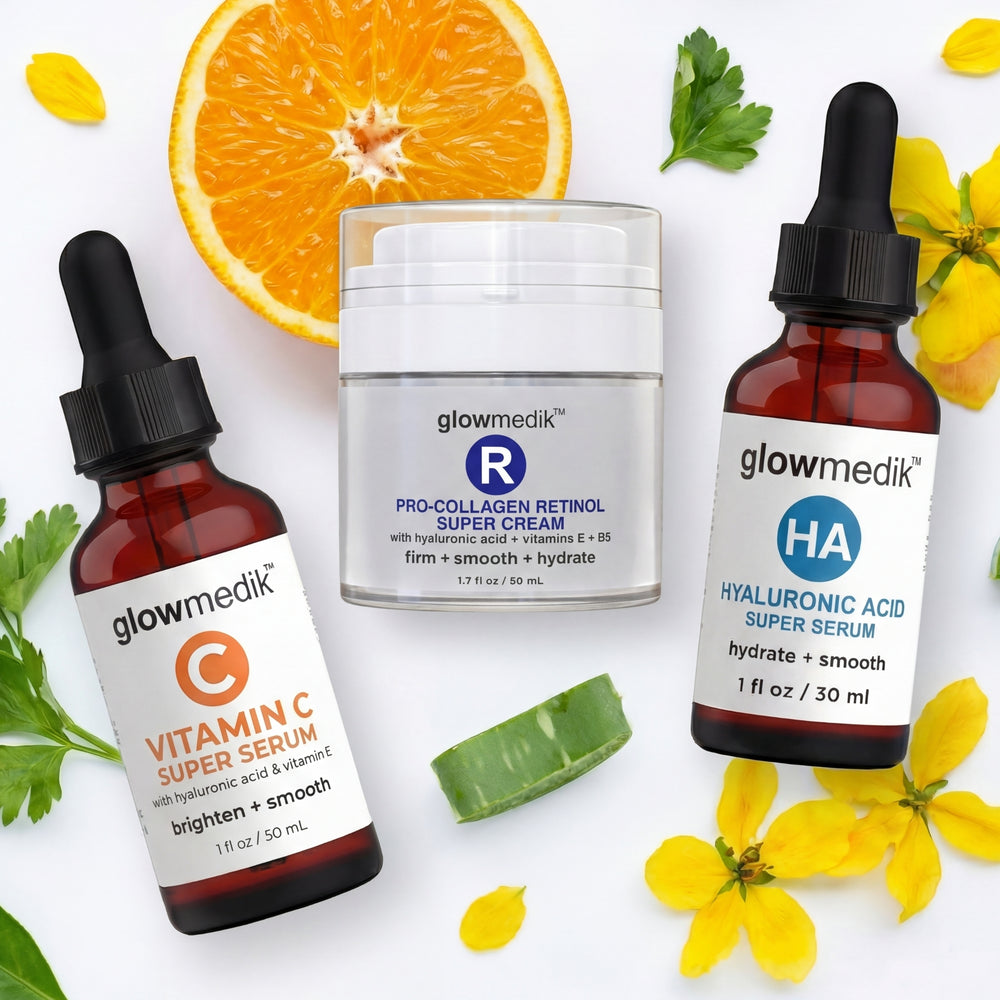 Glowmedik skincare products including Vitamin C serum, Pro-Collagen Retinol Super Cream, and HA Super Serum on a white background with orange and yellow flowers depicting the natural ingredients.