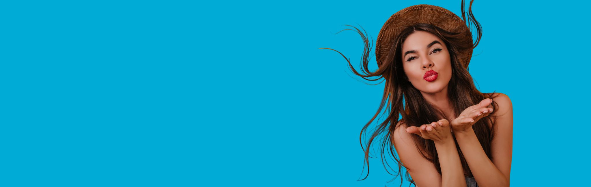 Woman blowing a kiss against a blue background
