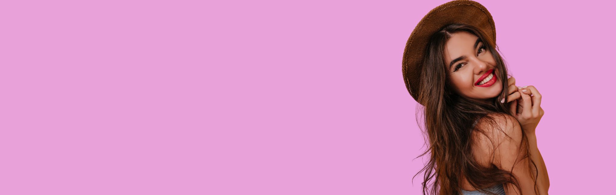 Woman wearing a hat on a pink background