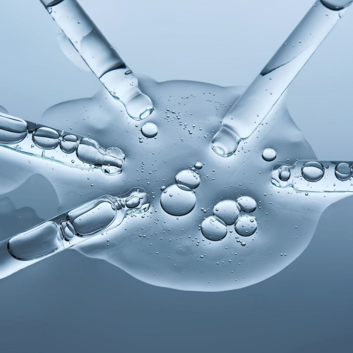 Close-up of clear liquid with bubbles on a blue background representing tri peptide complex